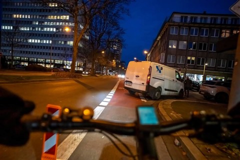 Cycling in the city, in the dark, in the evening, cycling on a bike lane, marked, delivery vehicle