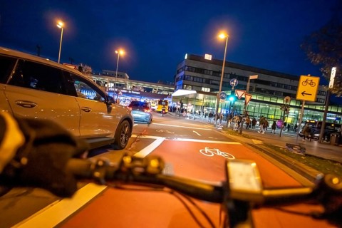 Cycling in the city, in the dark, in the evening, cycling on a bike lane, marked in red to alert