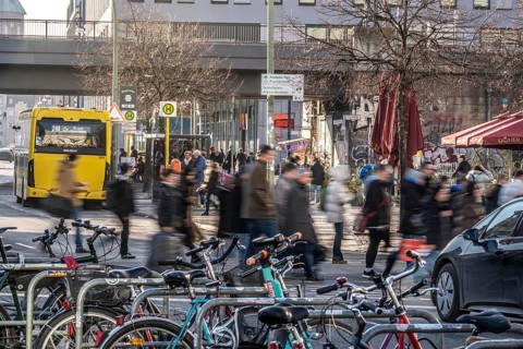 Passers-by on a GrunerstraÃŸe pedestrian crossing near Alexander Platz, bicycle parking lot in