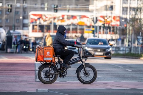 Lieferando delivery service driver, with moped-style e-bike, fat bike, model Koolux, at delivery,