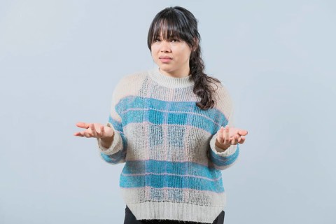 Confused asian woman spreading hands bewildered isolated. Unsure female with face worried