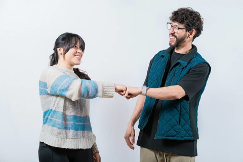Attractive couple smiling and bumping fists. Smiling couple bumping fists, isolated