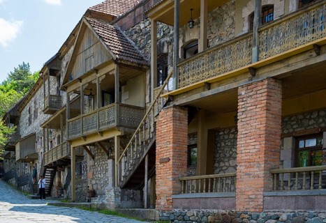 Row of old buildings with wooden verandas and brick walls on a cobblestone street in a quiet place,