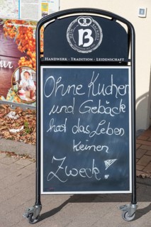 Blackboard with slogan in front of a café, Without cake and pastry, life has no purpose,