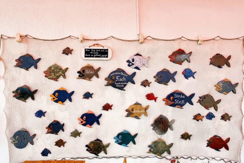 Maritime decoration, various wooden fish in a fishing net, funny signs, garden restaurant,