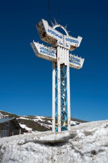 A sign in the snow at a mountain station under clear blue sky, Goderdzi Pass, Adjara region,