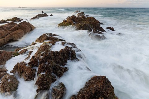 The Cape Byron Lookout at high tide. Rocks and anglers in golden light. Byron Bay, New South Wales,
