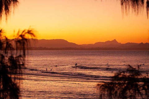 View of the ocean and Wategos Beach on the promenade at sunset. Mt- Warning, Wollumbin in the