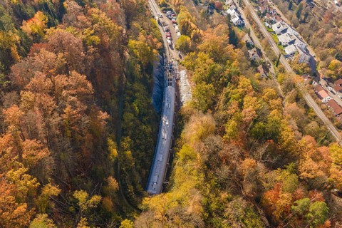 Bird's-eye view of a tunnel construction project integrated into an urban and autumnal forest