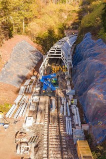 Railway tracks with crane and workers working on tunnels in autumn, Hermann Hesse Railway bat