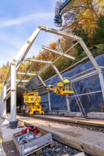 Construction work at a tunnel entrance in autumn with yellow construction equipment and visible
