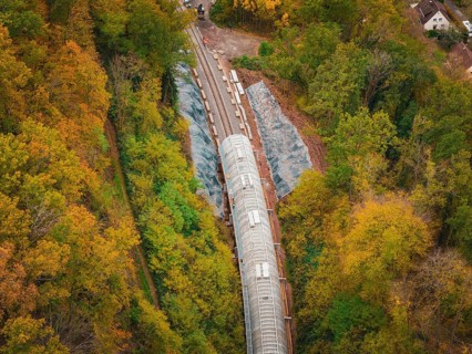Construction site of a tunnel from above in autumn forest with green and colorful trees, Hermann