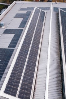 Close-up of a roof with two rows of solar cells, including some technical details, PV on Walther