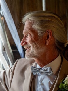 Elderly couple's wedding, groom looking outside, elderly man with long hair, ponytail and bow tie