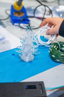 Small plastic Christmas tree on craft table with cable in hand, Jugend Forschungszentrum Nagold,