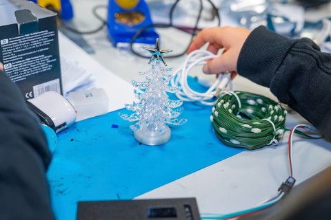 Craft table with small plastic Christmas tree and cables in hand, Jugend Forschungszentrum Nagold,