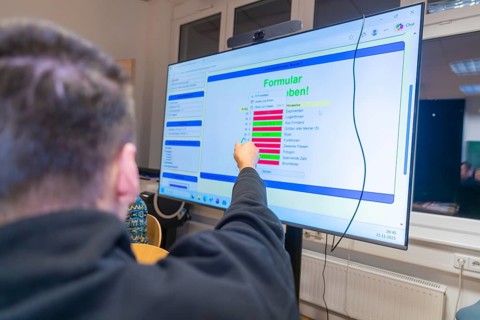 Person interacting with digital content on a large screen, Jugend Forschungszentrum Nagold, Calw