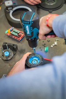 Person using a drill to assemble parts at a table, Jugend Forschungszentrum Nagold, Calw district,