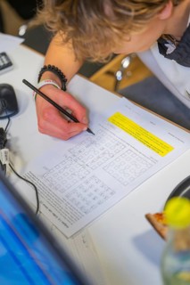Young person working on math problems at a desk, Jugend Forschungszentrum Nagold, Calw district,