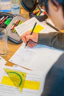 Person writes notes on paper using multiple tools, Jugend Forschungszentrum Nagold, Calw district,