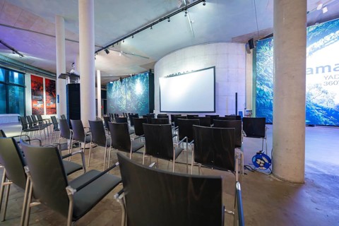 Empty conference room with chairs and a large projection screen under a high roof, Amazonia