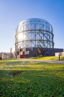 Round steel structure with green lawn underneath under blue sky, Amazonia exhibition, Gasometer,