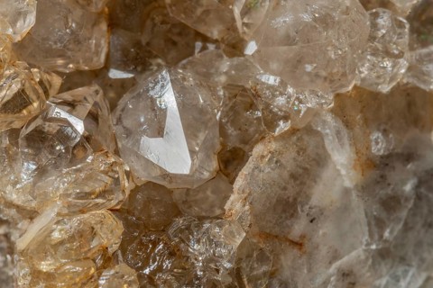 Bright, square crystals are visible on a piece of rock. The light underlines their structure and