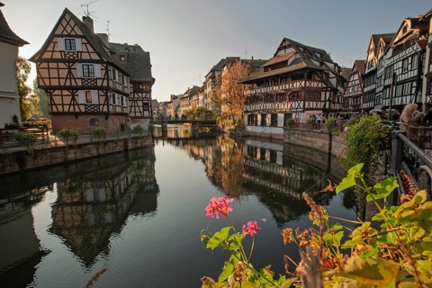 The colorful half-timberne houses of Little France are reflected in the calm waters of the river in