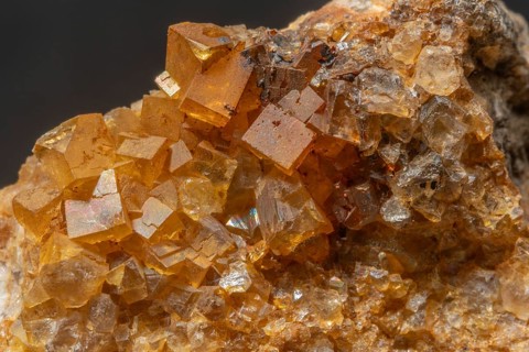 Brilliant crystals in blue and orange colors are visible in this mineral formation. They are