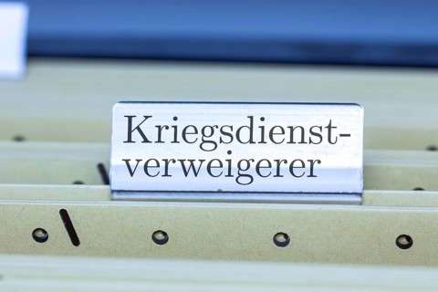 (photo montage) Sign with the inscription CONSCIENTIOUS OBJECTOR on a hanging file register