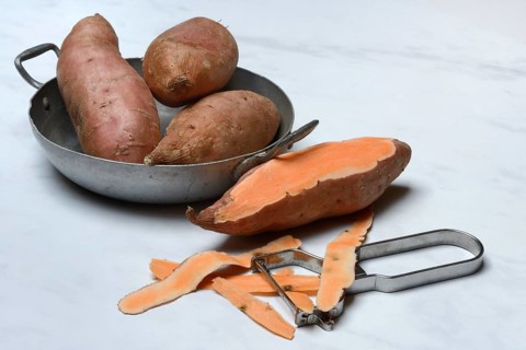 Sweet potatoes in skin and potato peeler, Ipomoea batatas