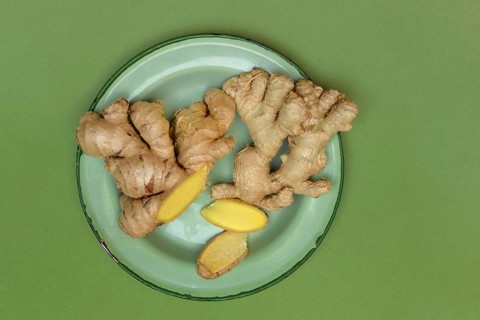 Ginger tubers and ginger slices on plate, Zingiber officinale