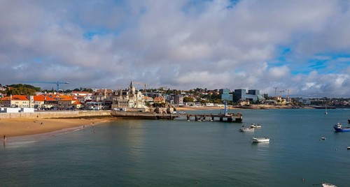View of the old town and a small stretch of beach by the sea, Cascais, Portugal