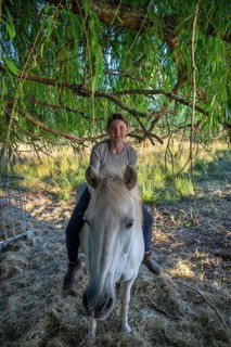 Young girl sitting on her horse under a tree, Othenstorf, Mecklenburg-Western Pomerania, Germany