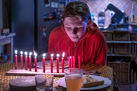 Young girl blowing out her thirteen burning birthday candles, Othenstorf, Mecklenburg-Western