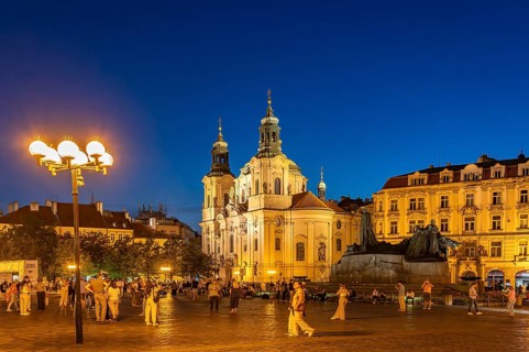 The Baroque St. Nicholas Church and the Jan Hus Memorial on Old Town Square at dusk, Prague, Czech