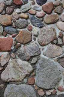 Irregular rough stones with rich texture in a wall
