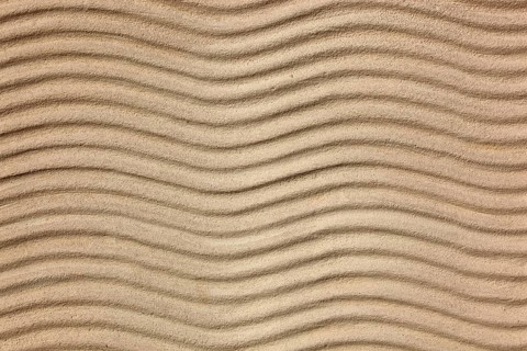 Beige sand with uniform wave patterns