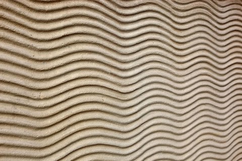 Close-up of beige sand texture with curved lines