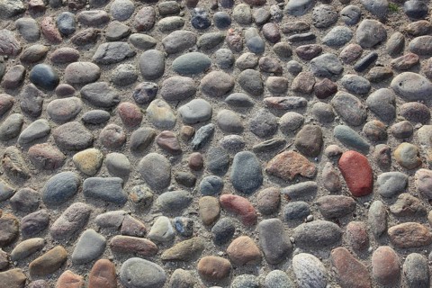 Round paving made of multi-coloured stones with a rough surface