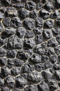 Detail of a wall of black, irregular rocks