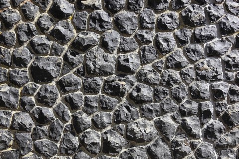 Close-up of a wall made of black textured stones