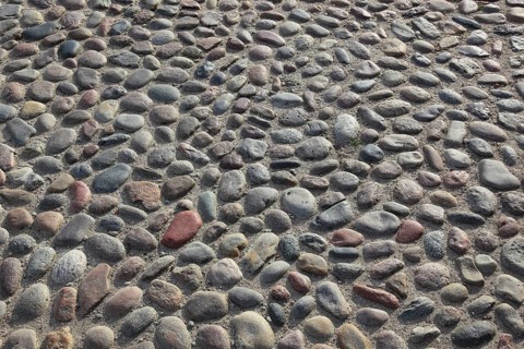 A floor of gray, round cobblestones with an uneven surface