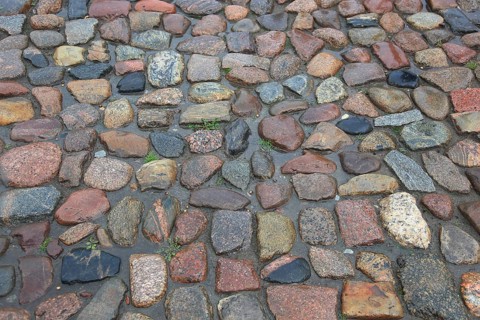 Wet cobblestones with irregular stones in natural earthy tones