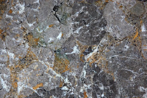 Multi-coloured granite with grey, white and orange elements, rich in structure