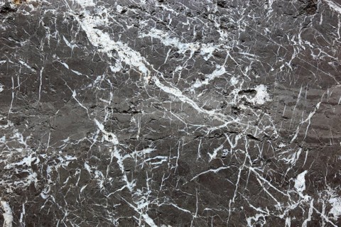 Black marble surface with white veins, exudes elegance and luxury
