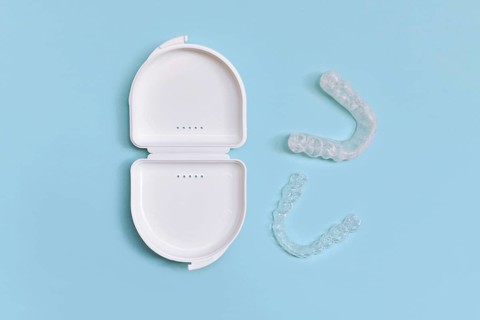 Customized transparent dental teeth bite guard clear aligners for lower jaw in white case on blue