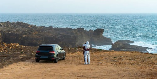 Young couple in love standing on the coast of Farol de Cabo Raso lighthouse, SÃ£o Bras de Sanxete