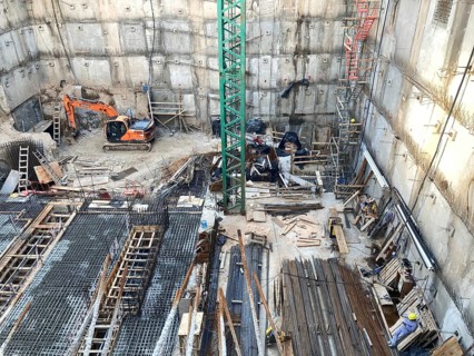 View of a construction site in a deep excavation pit, concrete work with lots of reinforcements,