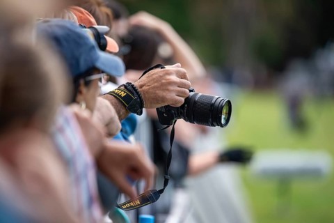 A man's hand holds a Nikon DSLR camera during a sporting event in Buenos Aires, Argentina